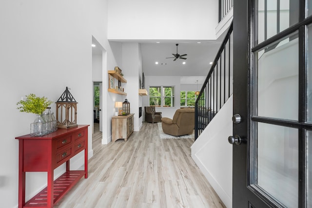 entrance foyer featuring a high ceiling, ceiling fan, and light hardwood / wood-style floors