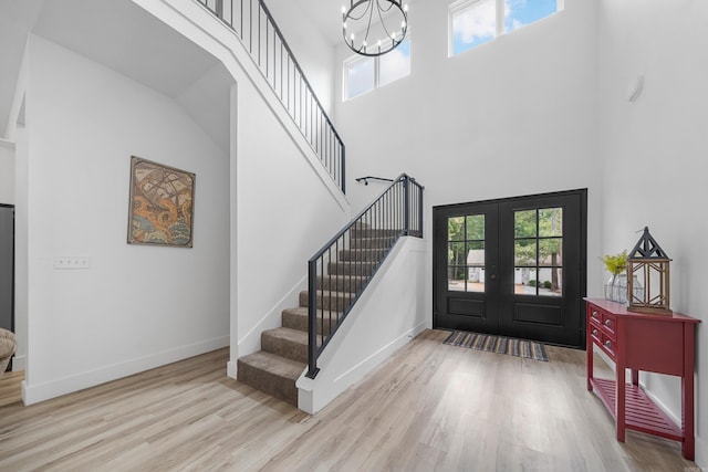 entrance foyer featuring light hardwood / wood-style floors, french doors, and a high ceiling