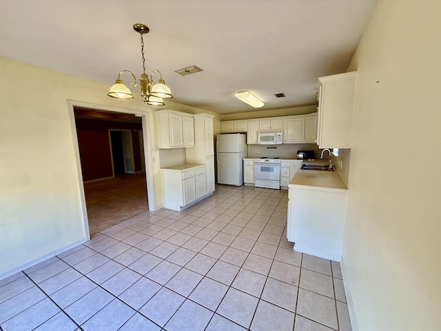 kitchen featuring sink, white cabinets, light tile patterned floors, a notable chandelier, and white appliances