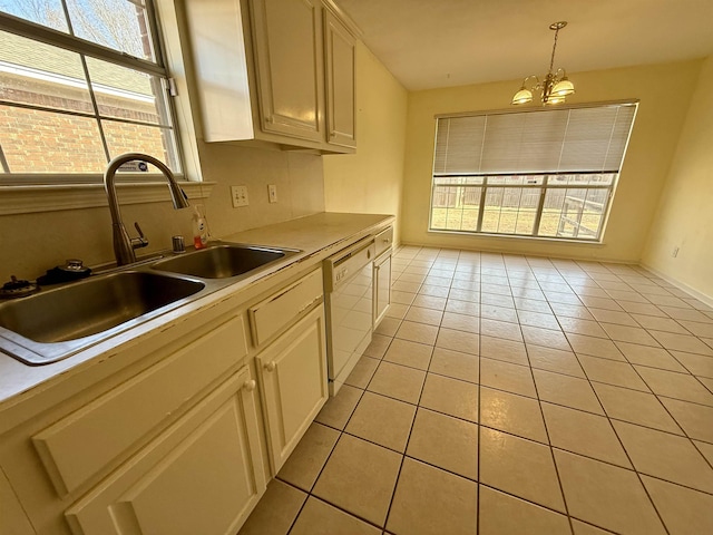 kitchen with sink, an inviting chandelier, hanging light fixtures, light tile patterned floors, and white dishwasher