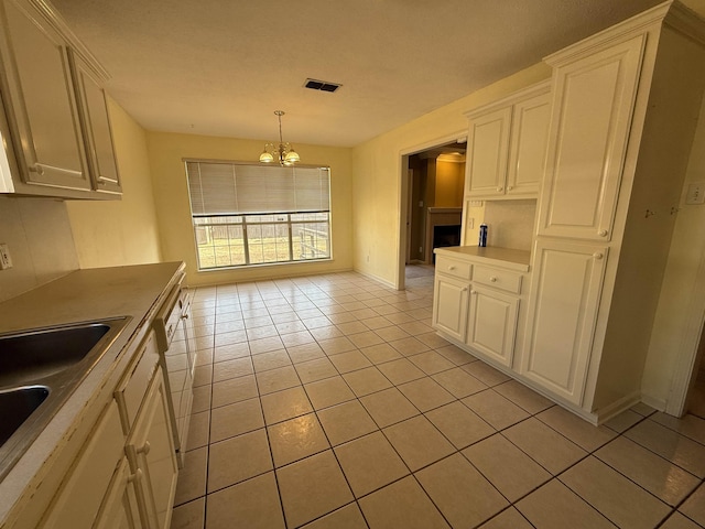 kitchen featuring pendant lighting, white cabinetry, and light tile patterned floors