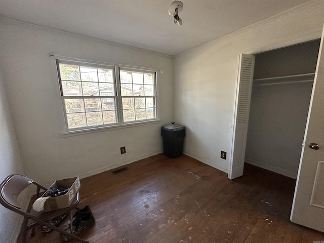 unfurnished bedroom with crown molding, dark hardwood / wood-style floors, and a closet