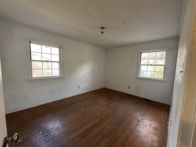 empty room with crown molding and dark hardwood / wood-style flooring