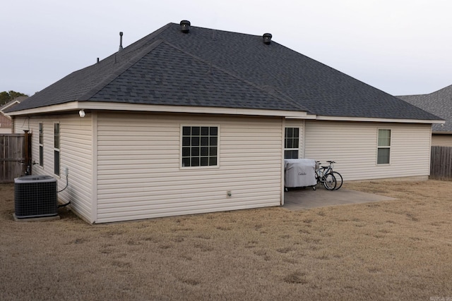 back of house with central AC and a lawn