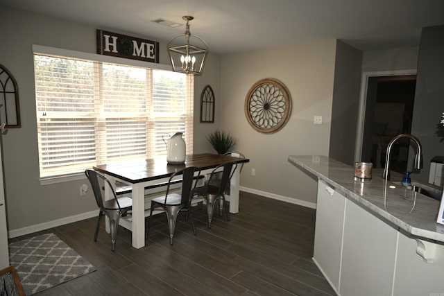 dining space with dark hardwood / wood-style flooring, sink, and an inviting chandelier