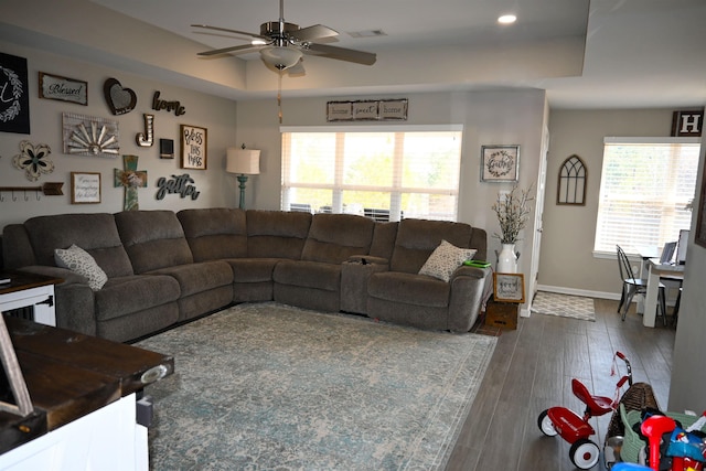 living room featuring ceiling fan, a raised ceiling, and hardwood / wood-style floors