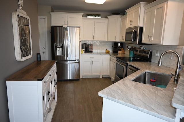 kitchen with backsplash, stainless steel appliances, sink, and white cabinets