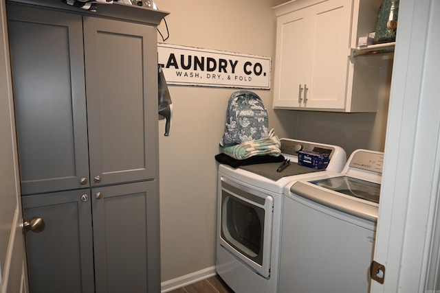 laundry room featuring washer and dryer, dark hardwood / wood-style flooring, and cabinets