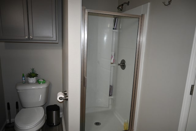 bathroom featuring toilet and an enclosed shower