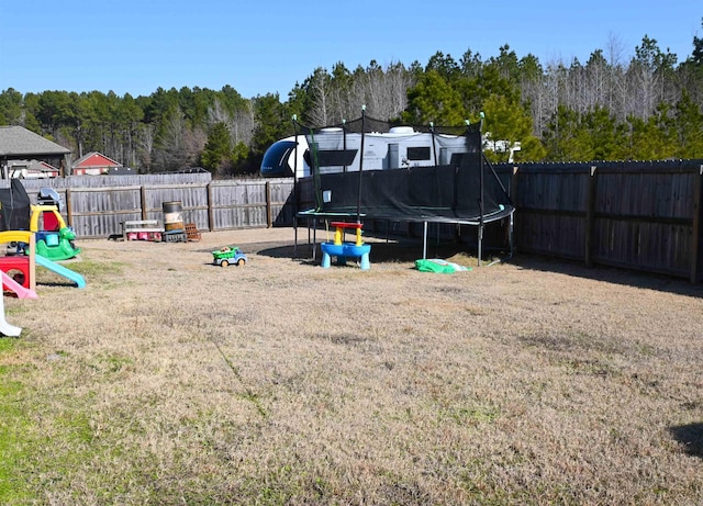 view of yard featuring a trampoline and a playground