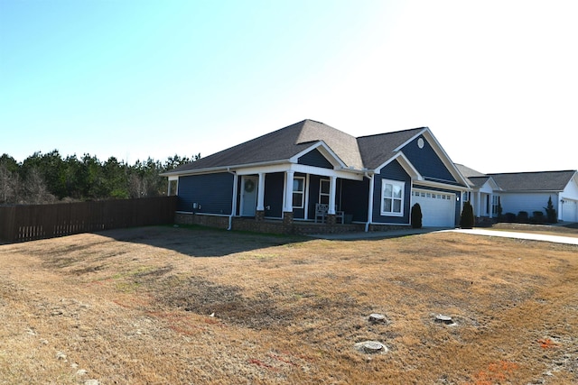 view of front facade with a garage, a porch, and a front yard