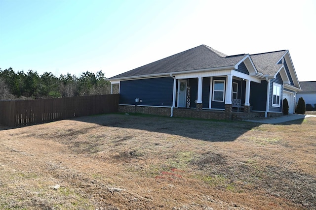 view of side of home with a yard and covered porch