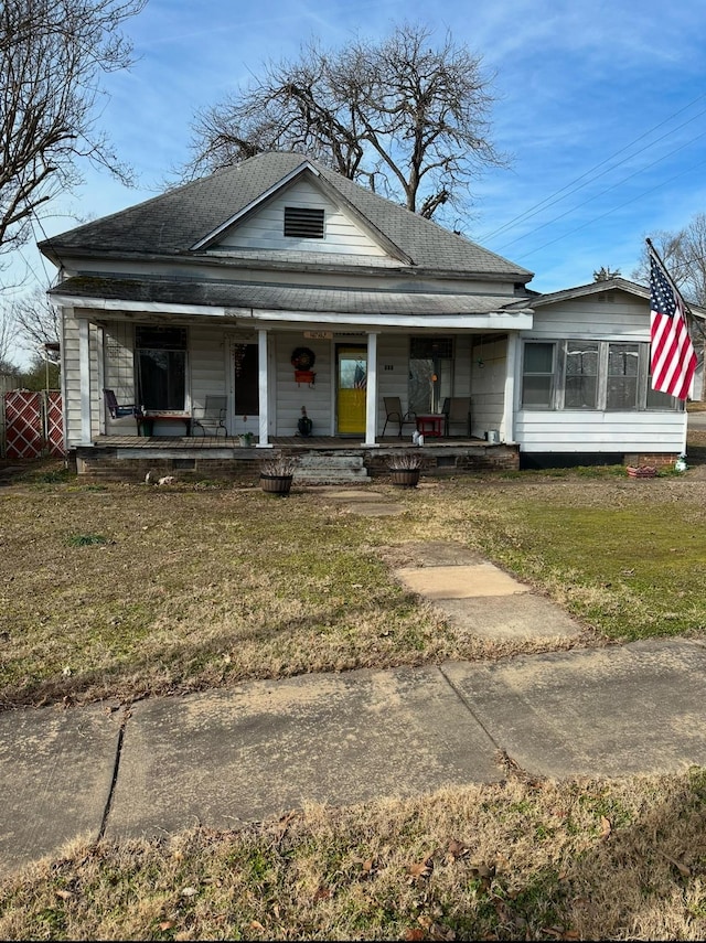 view of front of home with a front yard and a porch