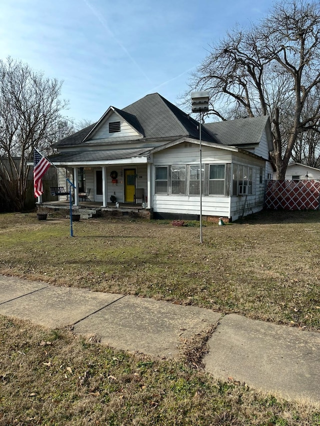 view of front of house with covered porch and a front lawn