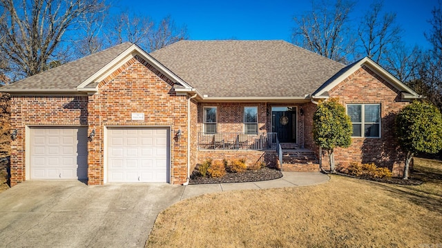 front facade featuring a garage, covered porch, and a front lawn