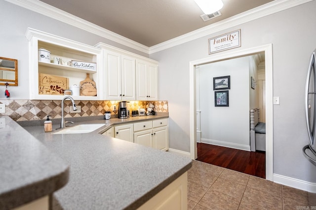 kitchen with tile patterned flooring, white cabinetry, sink, and ornamental molding