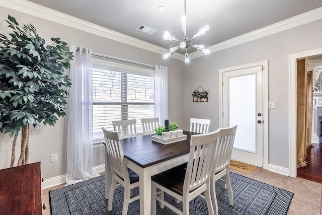 dining room featuring a notable chandelier, ornamental molding, and light tile patterned floors