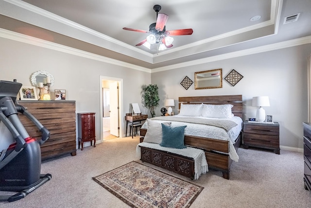 carpeted bedroom with crown molding, a tray ceiling, ceiling fan, and ensuite bathroom