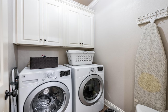 laundry room with crown molding, cabinets, and washing machine and dryer