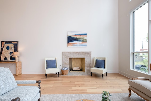 sitting room with a healthy amount of sunlight, a fireplace, and light hardwood / wood-style floors