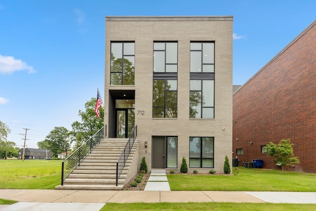 contemporary house featuring cooling unit and a front lawn