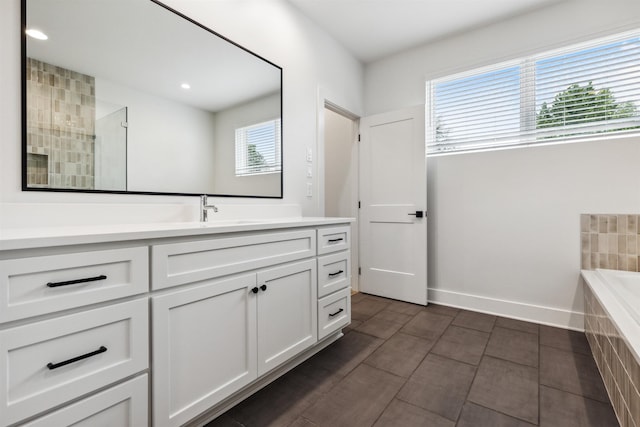 bathroom featuring vanity, shower with separate bathtub, and a wealth of natural light