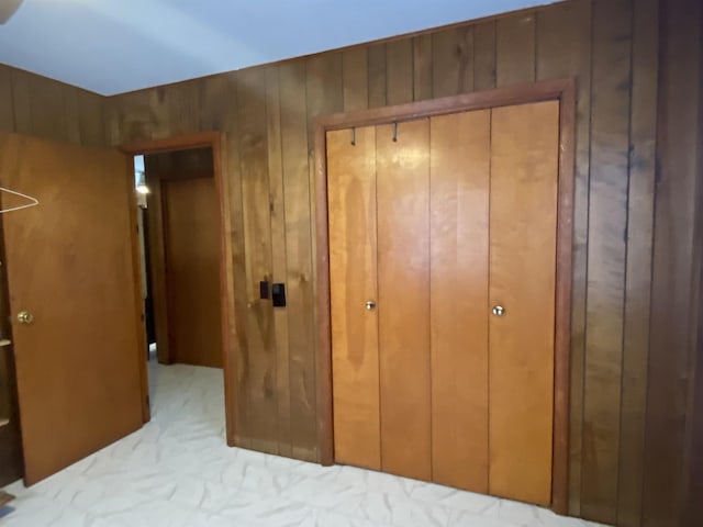 bedroom featuring a closet and wood walls