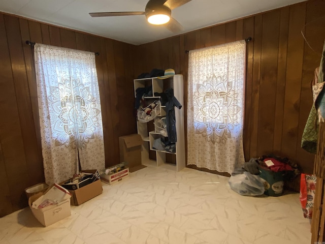 mudroom with ceiling fan, wooden walls, and a healthy amount of sunlight