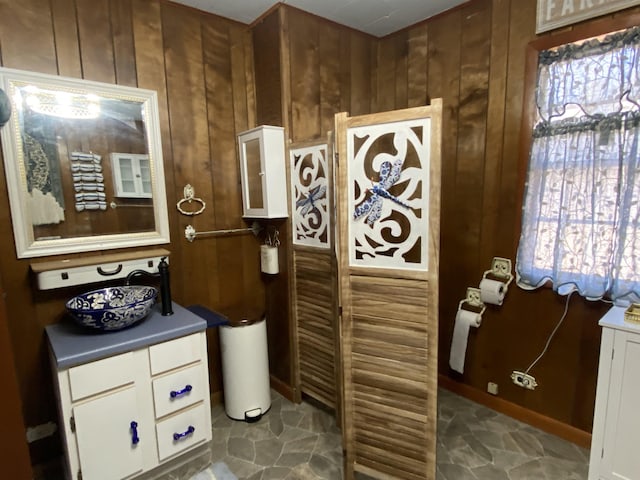 bathroom featuring wooden walls and sink