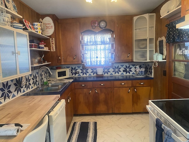 kitchen featuring sink, white appliances, and decorative backsplash