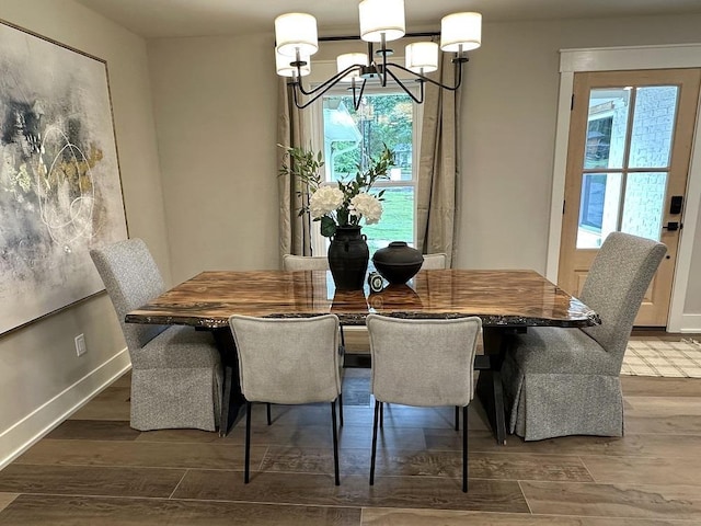 dining space featuring hardwood / wood-style flooring and a chandelier