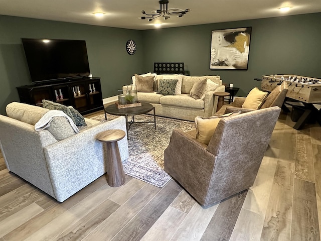 living room with a notable chandelier and light wood-type flooring