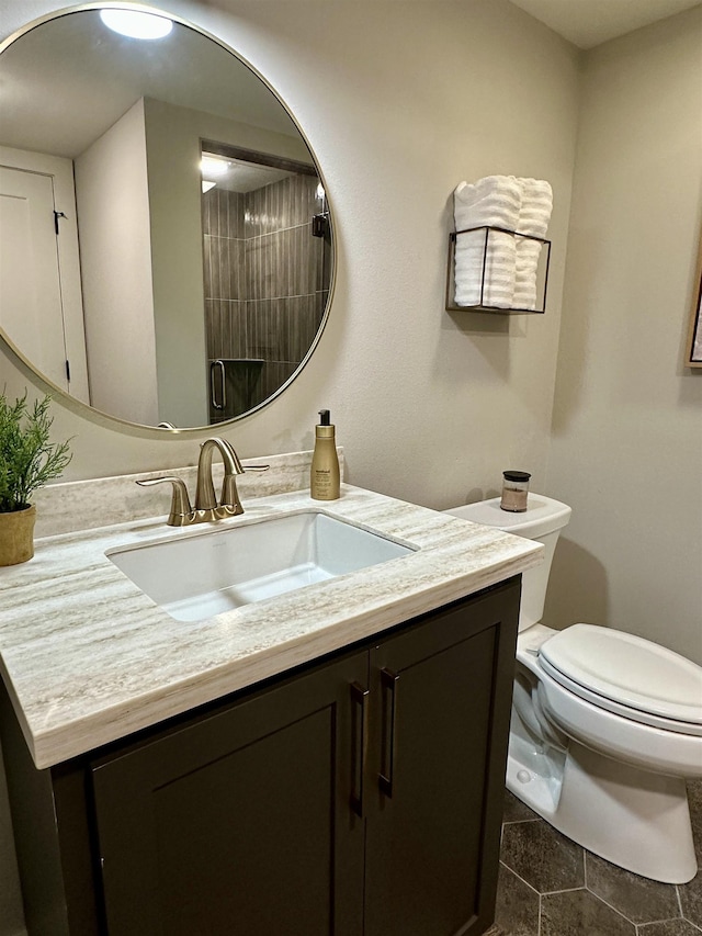 bathroom featuring vanity, a shower, and toilet