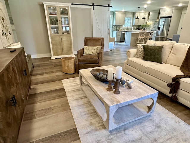 living room with a barn door and light hardwood / wood-style floors