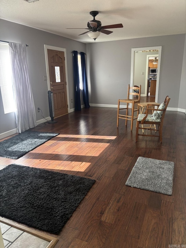 foyer entrance with ceiling fan and dark hardwood / wood-style flooring