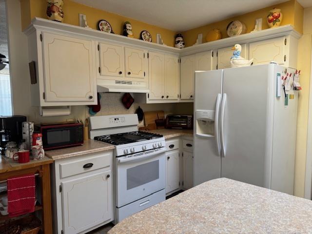 kitchen featuring white appliances and white cabinets