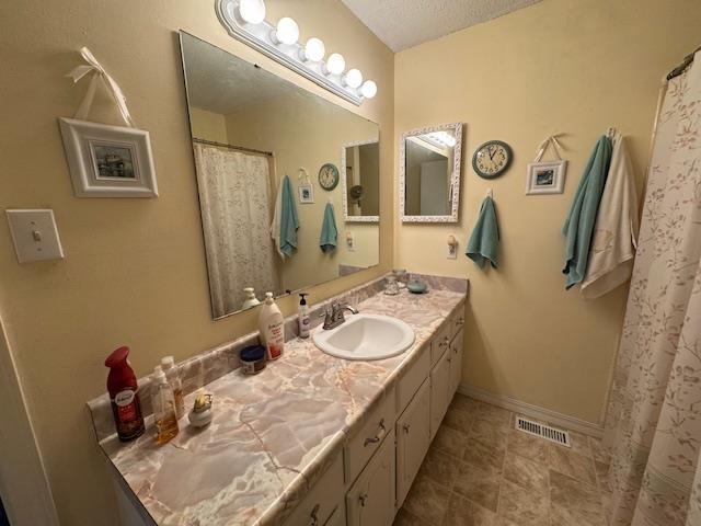 bathroom with vanity and a textured ceiling