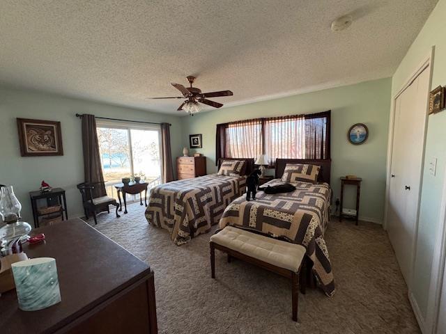 bedroom featuring a textured ceiling, a closet, ceiling fan, and carpet