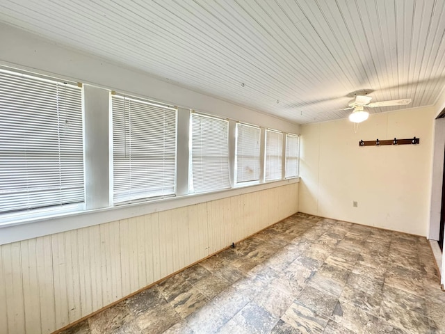 unfurnished sunroom featuring ceiling fan