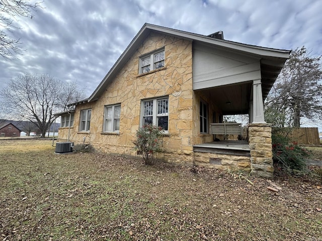 view of side of property featuring central AC and covered porch