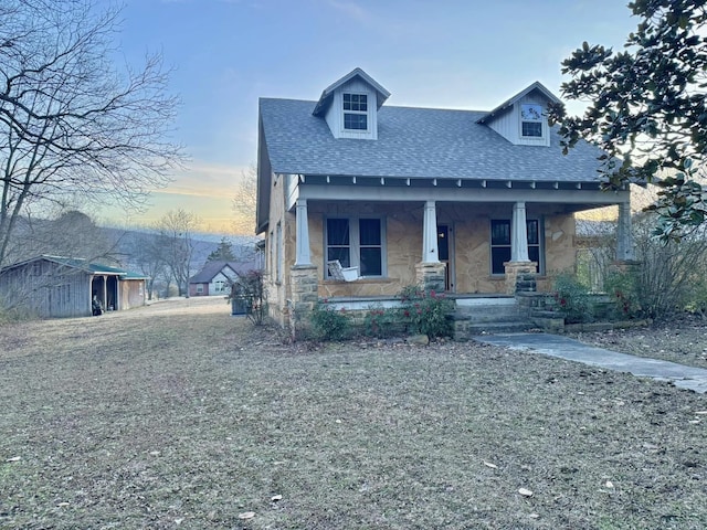 view of front of house featuring a shed and covered porch