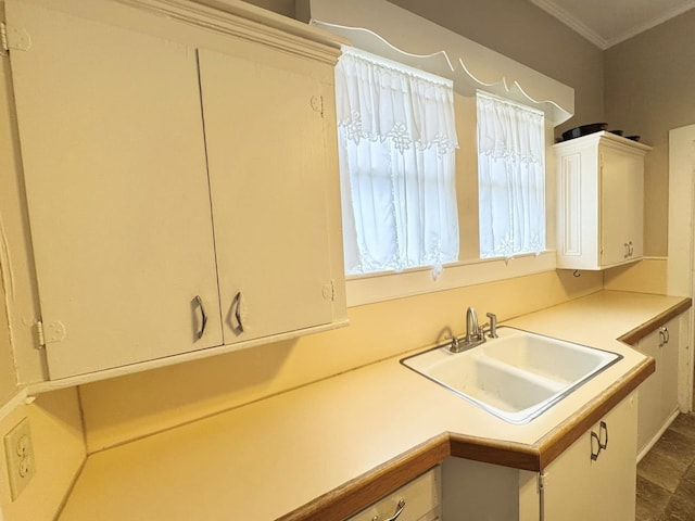 kitchen featuring ornamental molding, sink, and white cabinets