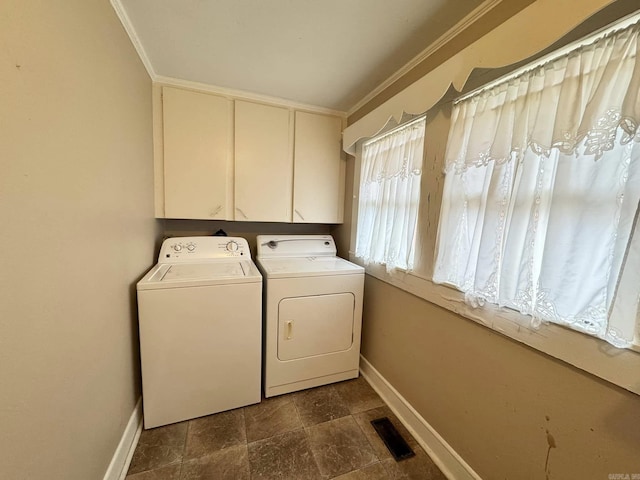 laundry area with cabinets, ornamental molding, and washer and clothes dryer