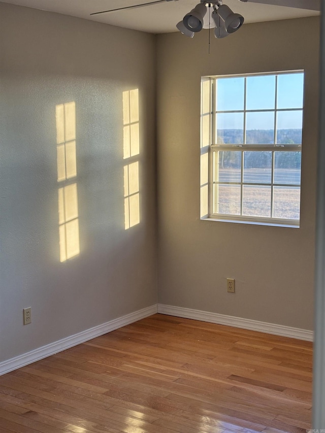 spare room with a mountain view, ceiling fan, and light hardwood / wood-style flooring