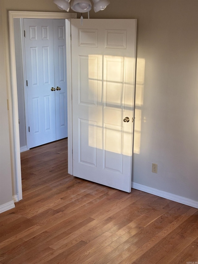 unfurnished bedroom with ceiling fan, hardwood / wood-style floors, and a closet