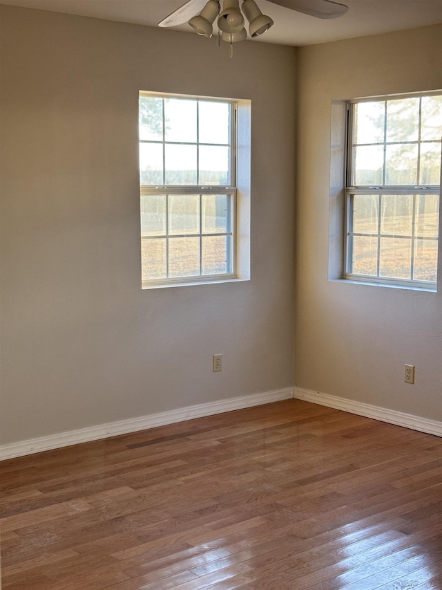 unfurnished room with ceiling fan, a healthy amount of sunlight, and wood-type flooring