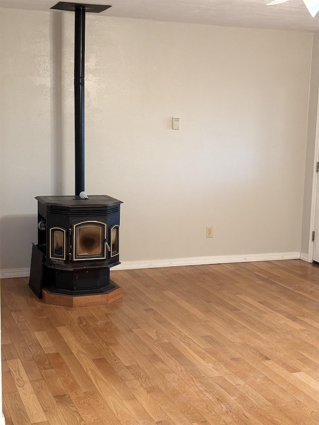 interior details with wood-type flooring and a wood stove