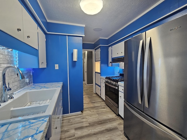 kitchen featuring white cabinetry, sink, ornamental molding, stainless steel appliances, and light hardwood / wood-style flooring