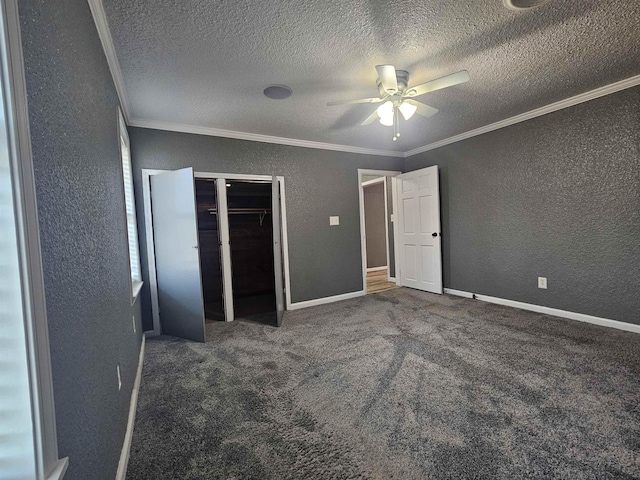 unfurnished bedroom featuring dark colored carpet, ornamental molding, and ceiling fan