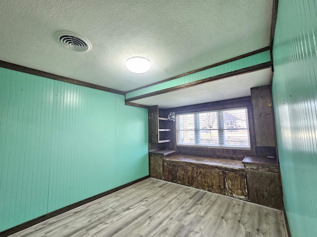 interior space featuring a textured ceiling and light hardwood / wood-style floors